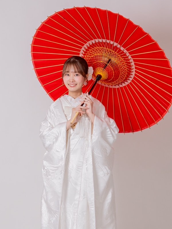 赤い和傘をさす白無垢姿の新婦