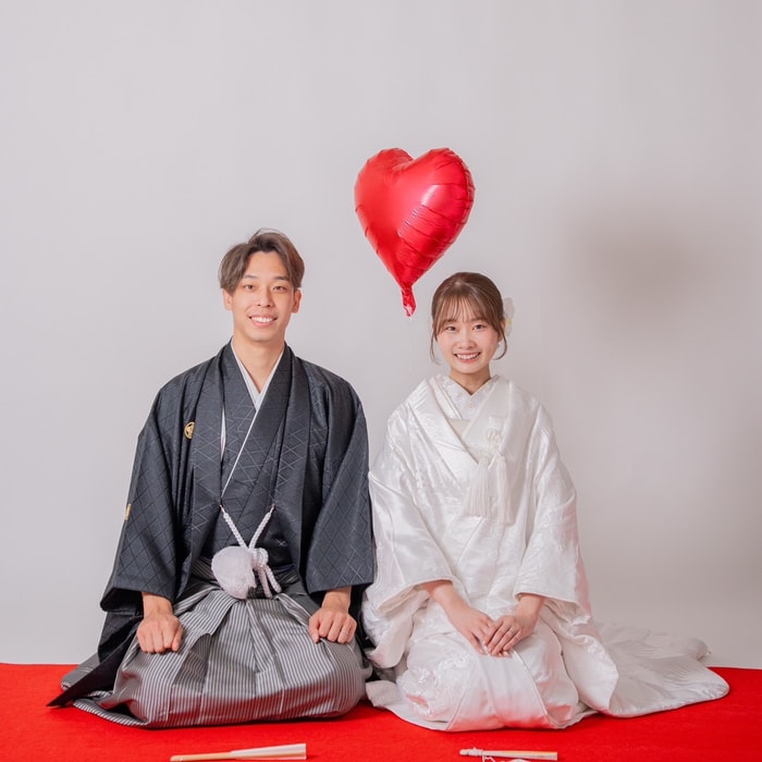 ハートの風船と座って微笑むふたり
